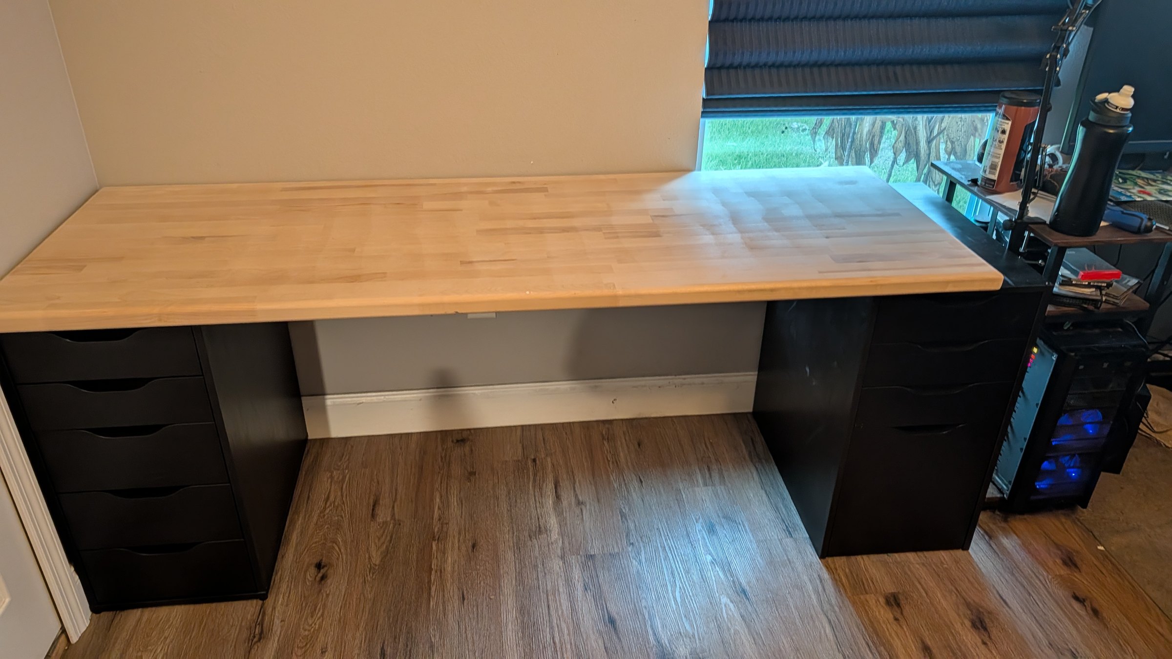 First six-foot butcher-block desk section dry-fitted on black drawer units