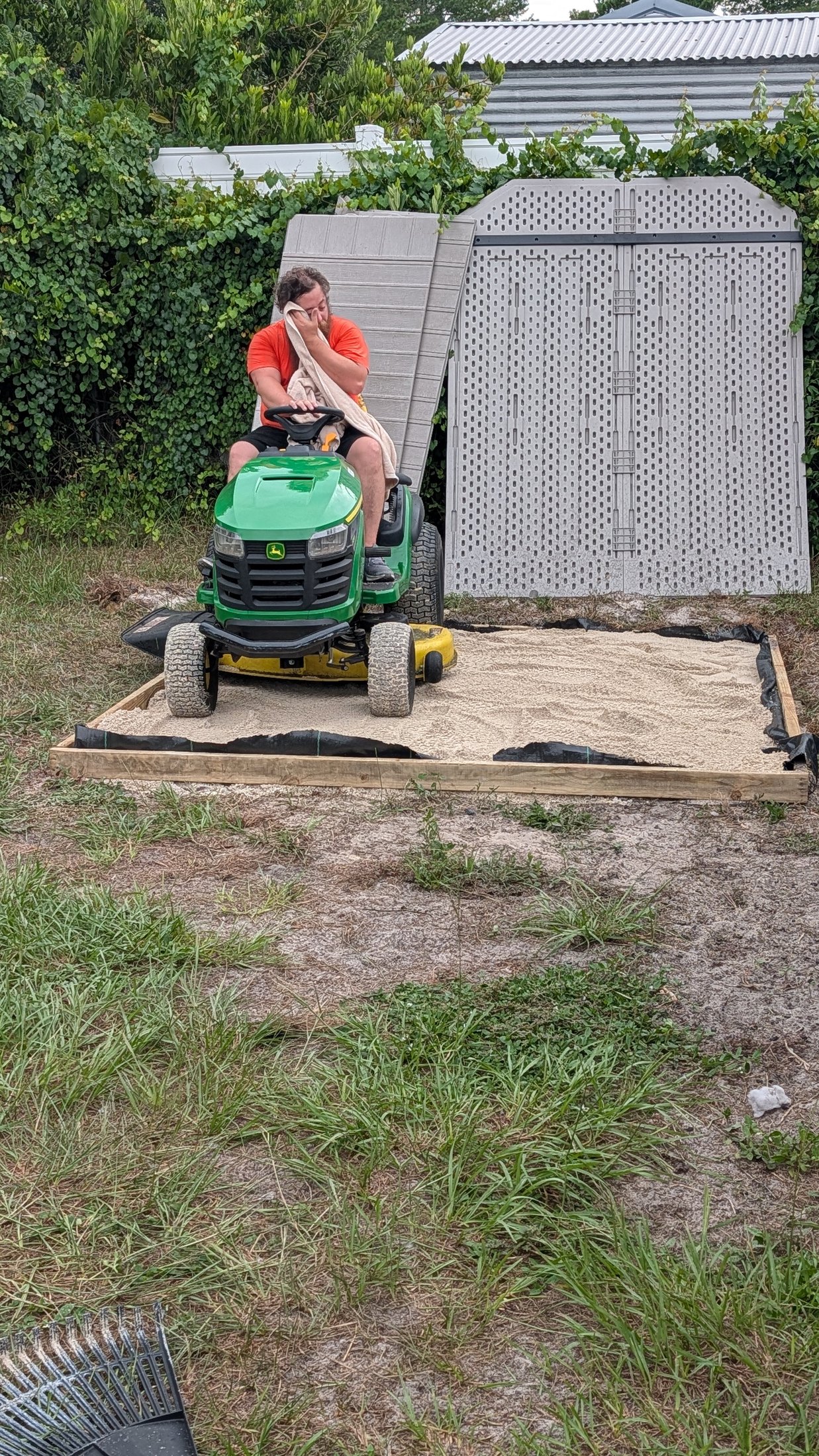 A riding mower being used to test and settle the shed foundation